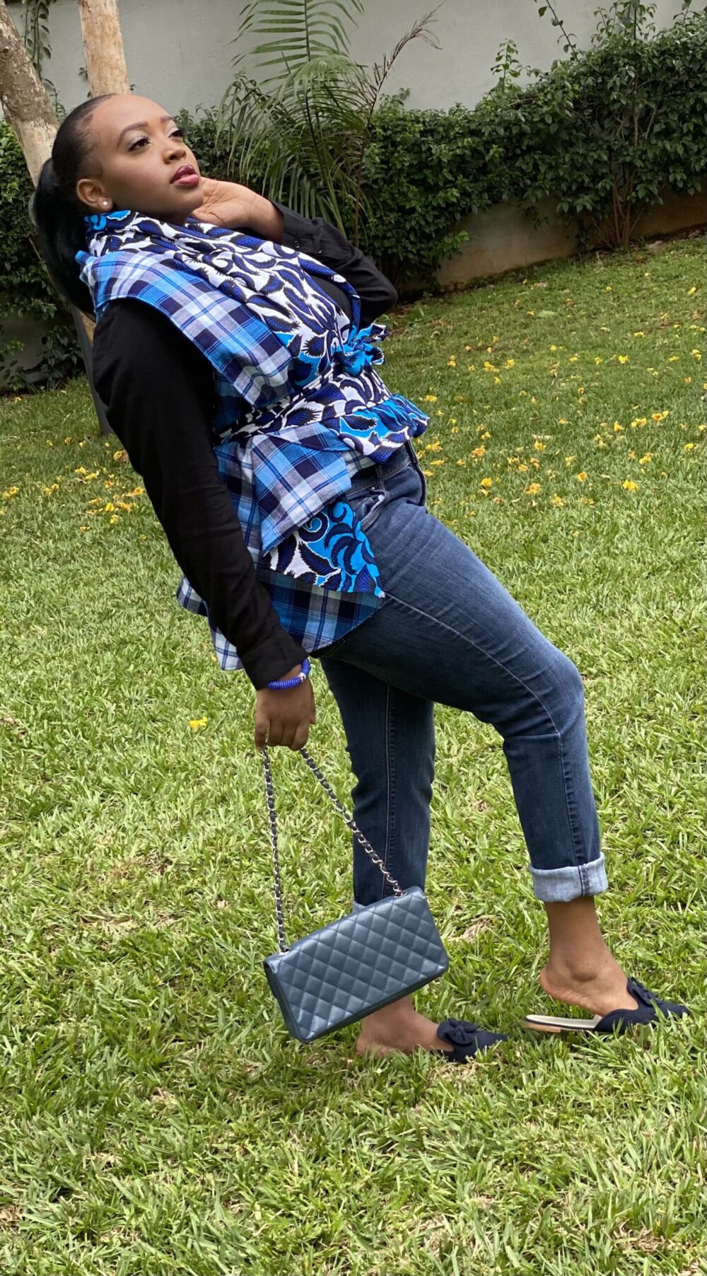 Blue Reversible Kapem with model standing sideways holding black purse